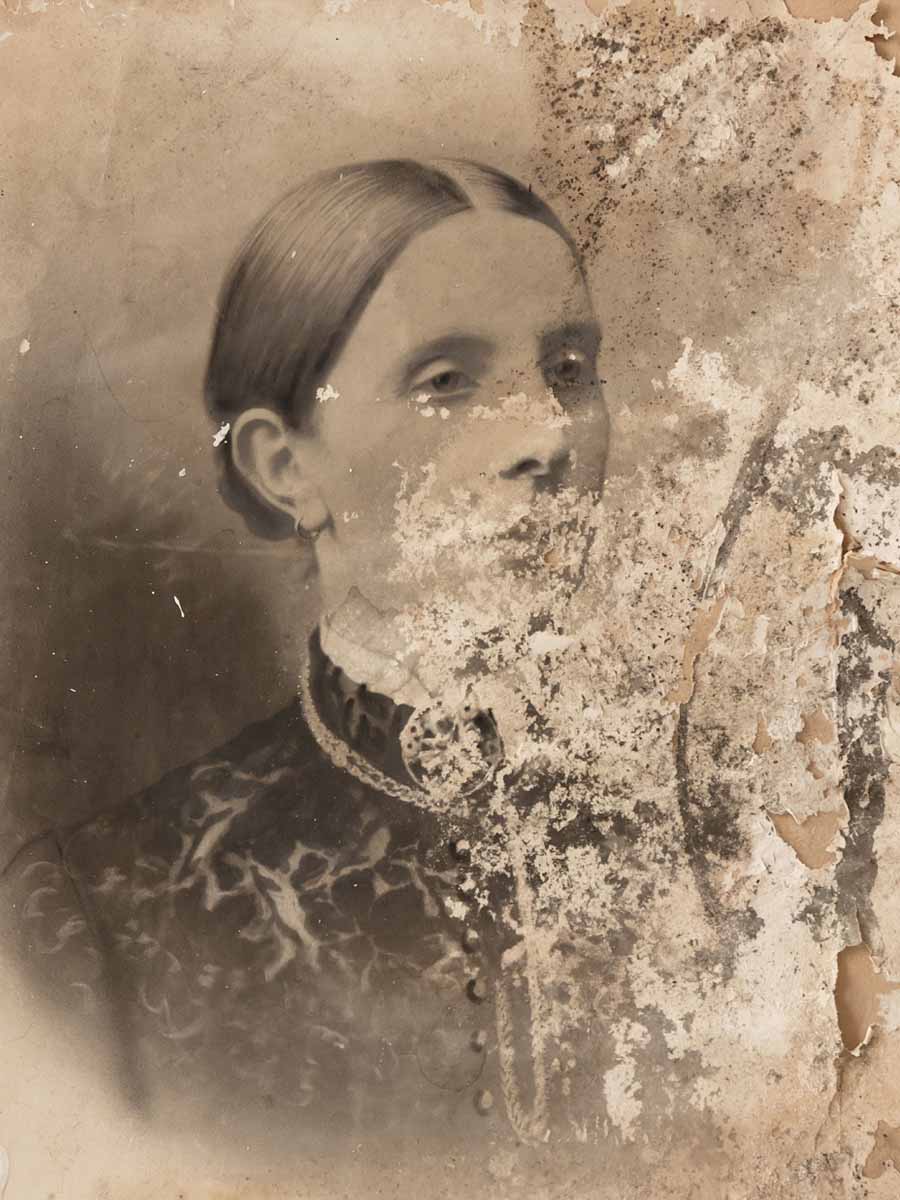 Original portrait of a woman with extensive flaking and damage across the face, clothing and right-hand side of the paper.